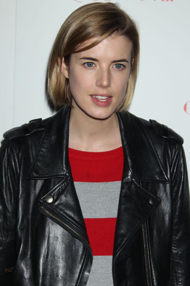 Eine Frau mit blonden Haaren und Lederjacke blickt in die Kamera.