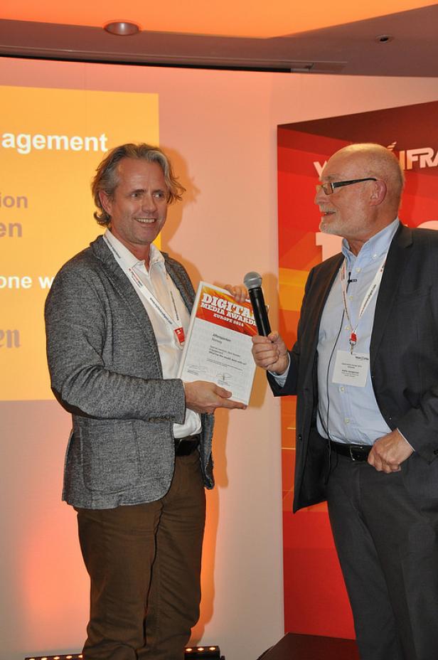 Ein Mann erhält eine Auszeichnung bei den Digital Media Awards Europe 2013.