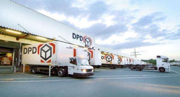 Mehrere DPD-Lieferwagen stehen vor einem Lagerhaus.