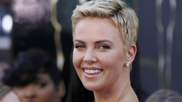 Nahaufnahme von Charlize Theron mit kurzem, blondem Haar und einem Diamantenohrring.