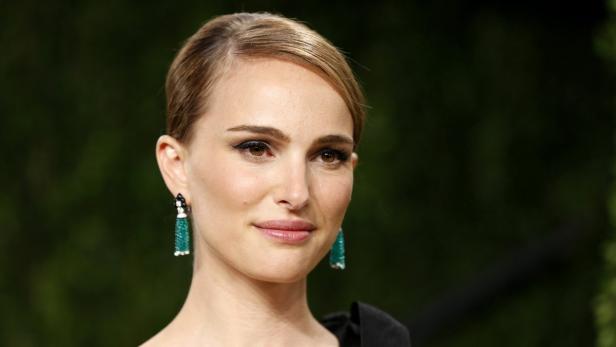 Ein Porträt von Natalie Portman mit grünen Ohrringen.