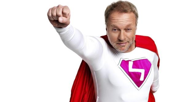 Ein Mann im Superheldenkostüm mit rotem Umhang und erhobener Faust.