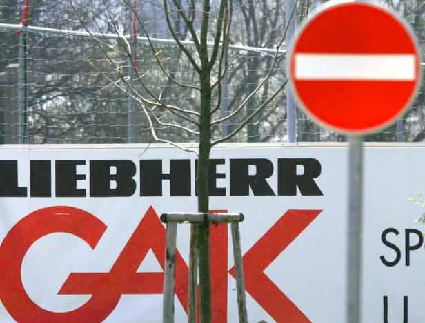 Ein Baum steht vor einem Werbeplakat von Liebherr und einem Verkehrsschild „Verbot der Einfahrt“.