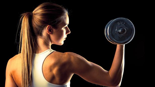 attractive young woman working out with dumbbells…
