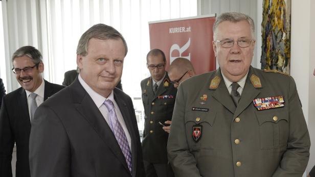 Zwei Männer in Anzügen und Uniformen stehen nebeneinander.