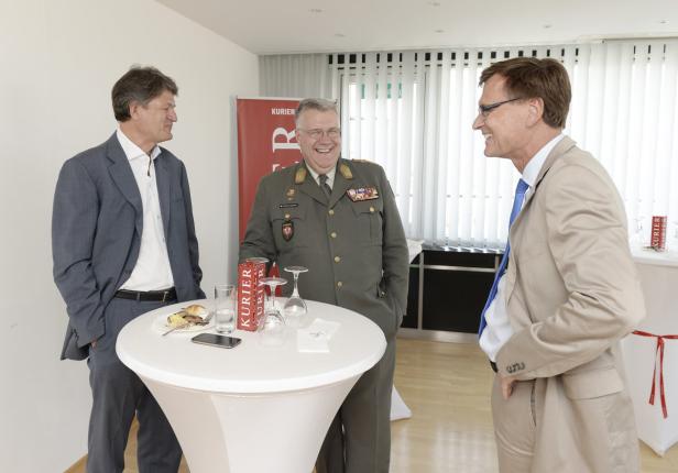Drei Männer unterhalten sich bei einer Veranstaltung des „Kurier“.