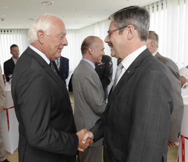 Zwei Männer in Anzügen geben sich die Hand.