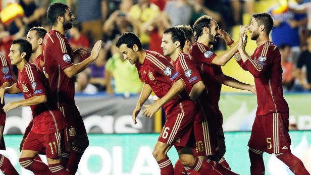 Spanische Fußballspieler feiern gemeinsam auf dem Spielfeld.