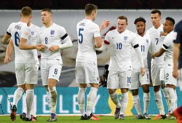 Eine Gruppe englischer Fußballspieler in weißen Trikots auf dem Spielfeld.