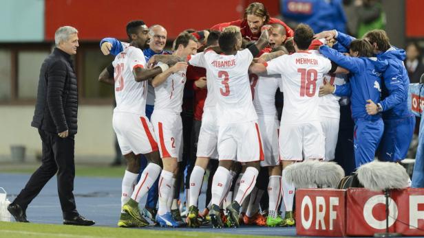Schweizer Fußballspieler feiern gemeinsam mit ihrem Trainer am Spielfeldrand.