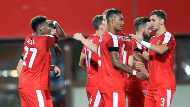 Österreichische Fußballspieler feiern gemeinsam in ihren roten Trikots.