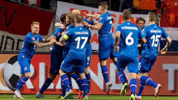 Isländische Fußballspieler feiern gemeinsam auf dem Spielfeld.