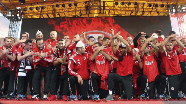 Eine Fußballmannschaft feiert einen Sieg auf einer Bühne.