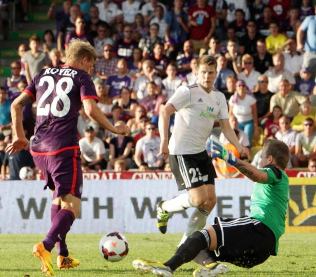 Ein Fußballspieler mit der Nummer 28 schießt auf das Tor, während der Torwart versucht, den Ball abzuwehren.