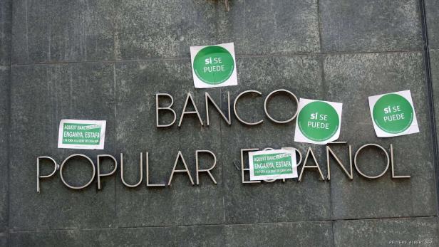 Die Fassade des „Banco Popular Español“ ist mit Protestaufklebern versehen.