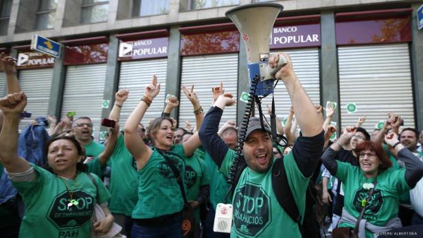 Eine Gruppe von Demonstranten protestiert vor einer Filiale der Banco Popular.