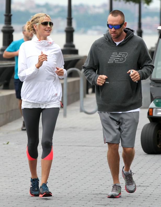 Heidi Klum und ihr Begleiter joggen an einem sonnigen Tag am Flussufer.