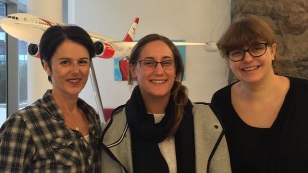 Drei Frauen posieren vor einem Modellflugzeug der Austrian Airlines.