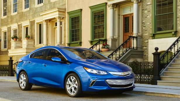 Ein blauer Chevrolet Volt parkt vor einem Stadthaus.
