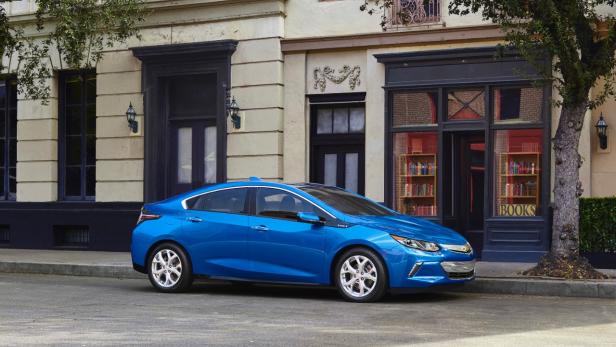 Ein blauer Chevrolet Volt parkt vor einem Gebäude mit einem Buchladen.