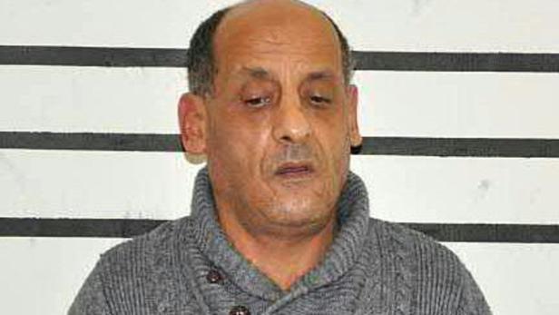 Ein Mann steht vor einer Wand mit horizontalen Linien.