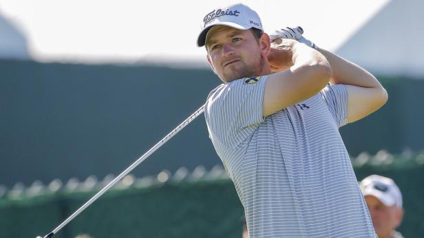 Ein Mann schwingt einen Golfschläger auf einem Golfplatz.