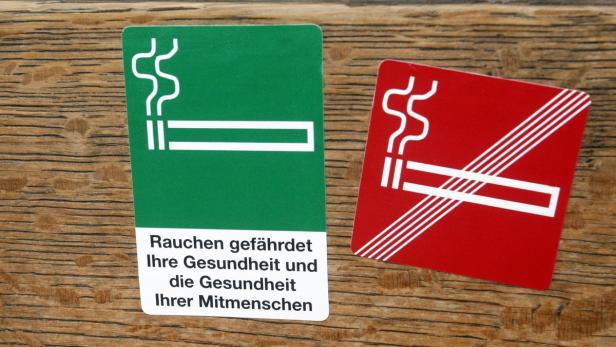 Ein grünes Schild mit der Aufschrift „Rauchen gefährdet Ihre Gesundheit“ und ein rotes „Rauchen verboten“-Schild.
