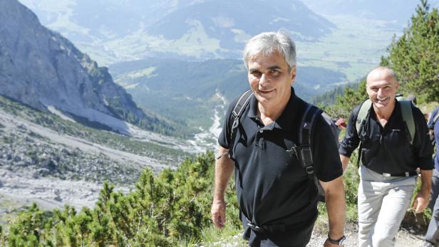 Zwei Männer wandern in den Bergen an einem sonnigen Tag.