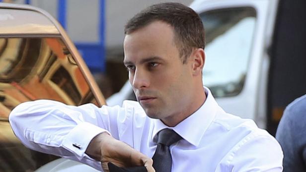 Oscar Pistorius in Hemd und Krawatte vor einem Auto.