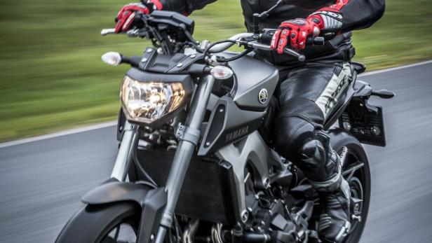 Ein Motorradfahrer auf einer Yamaha mit gelbem Helm fährt auf einer Rennstrecke.