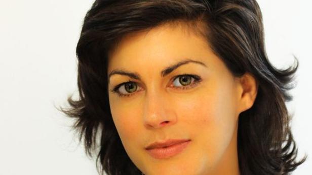 Porträt einer Frau mit braunen Haaren und grünen Augen.