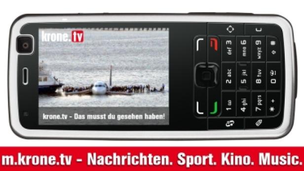 Auf dem Display eines Mobiltelefons ist ein Flugzeug im Wasser zu sehen.