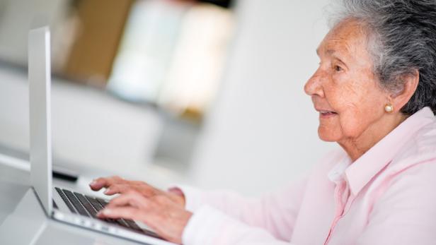 Elder woman using a computer and looking very happy