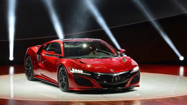Ein roter Acura NSX Sportwagen steht auf einer beleuchteten Bühne.