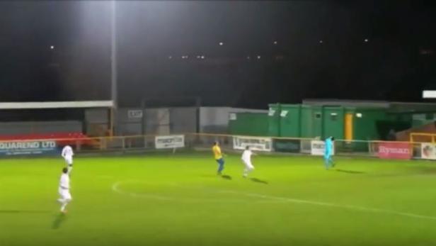 Fußballspieler in Aktion während eines Spiels bei Nacht.