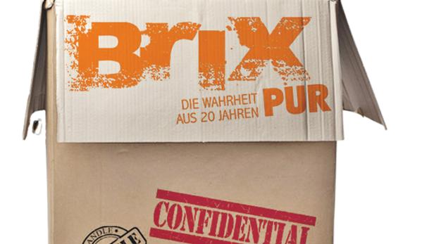 Ein Mann schaut aus einem Karton mit der Aufschrift „Brix – Die Wahrheit pur aus 20 Jahren“.