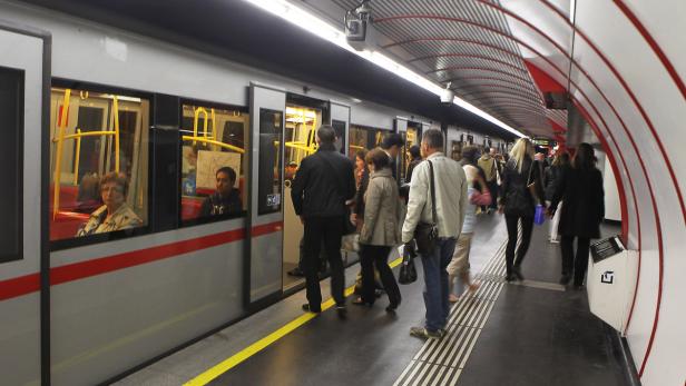 Menschen steigen in eine U-Bahn an einer Haltestelle ein.