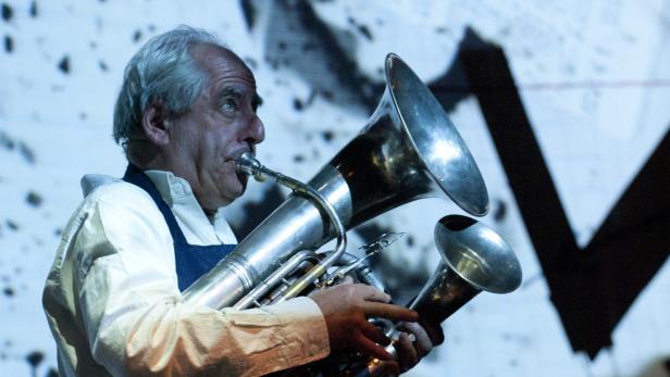 Ein Mann mit grauem Haar spielt ein Blechblasinstrument.