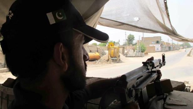 epa03807366 Pakistani police stands guard at a check point as authorities imposed a curfew after the district jail was attacked by Islamic militants, in Dera Ismail Khan, Pakistan, 30 July 2013. At least 13 people were killed and 248 inmates escaped during a Taliban assault on the prison in D. I. Khan. Tehrik-i-Taliban Pakistan spokesman Shahidullah Shahid claimed responsibility for the assault, saying it had involved more than 100 fighters including eight suicide bombers, two of whom detonated their explosives vest at the start of the attack. EPA/SAOOD REHMAN