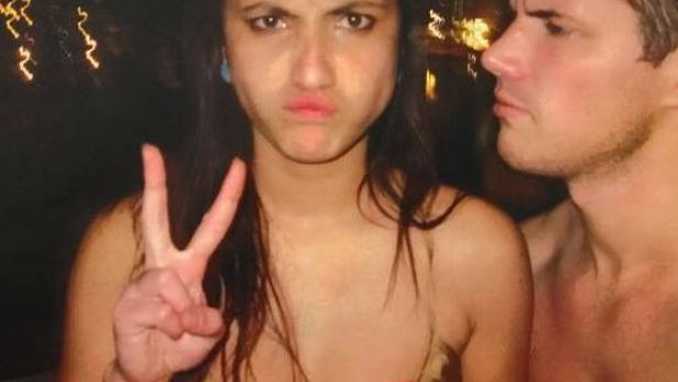 Eine Frau zeigt das Victory-Zeichen, während ein Mann daneben steht.