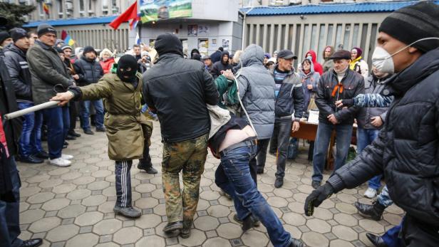Pro-Russian protesters detain a man during a rally