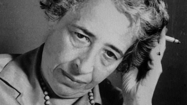 Hannah Arendt in einer Schwarzweißaufnahme mit einer Zigarette in der Hand.