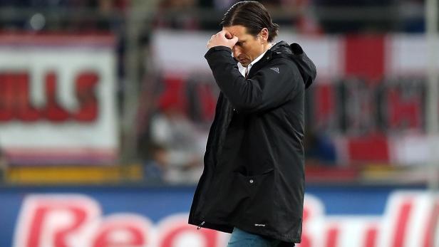 Ein Mann in einer schwarzen Jacke hält sich frustriert den Kopf.
