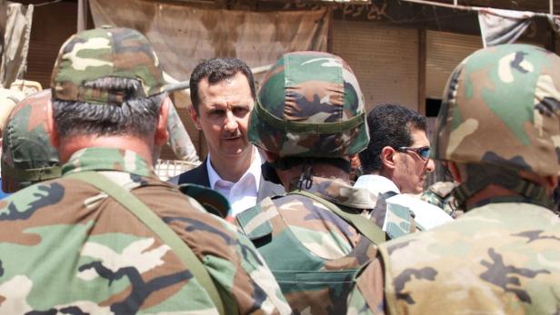 epa03810122 A handout photo made available by Syria&#039;s Arab News Agency (SANA) shows Syrian President Bashar Assad (C) inspecting a unit of the Syrian armed troops in the Damascus¸Äô suburb of Darayya, Syria, 01 August 2013. The visit came on the occupation of the Army Foundation Day. The city has witnessed fierce clashes over the past months between the Syrian army troops and armed groups. EPA/SANA / HANDOUT MANDATORY CREDIT: SANA HANDOUT EDITORIAL USE ONLY/NO SALES