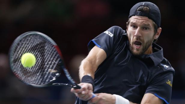 Ein Tennisspieler schlägt einen Ball mit seinem Schläger.