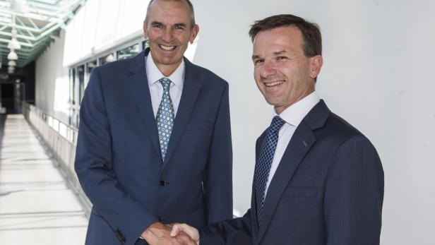 Zwei Männer in Anzügen schütteln sich die Hände.