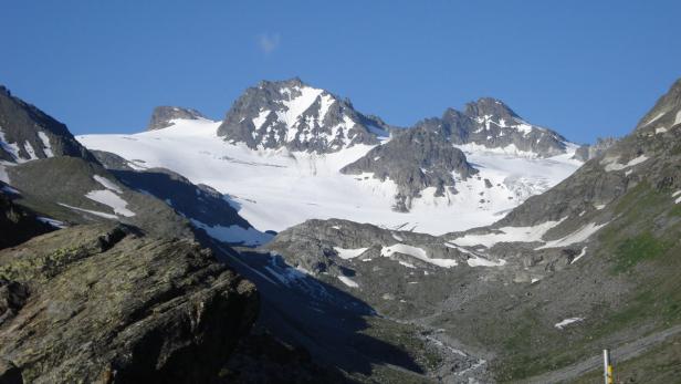 Eine Berglandschaft mit schneebedeckten Gipfeln unter einem blauen Himmel.