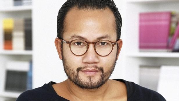 Ein Mann mit Brille und Bart vor einem Bücherregal.