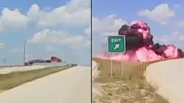 Ein Lastwagen fährt auf einer Straße, während im Hintergrund eine Explosion stattfindet.