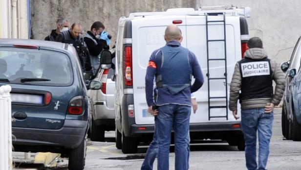 Polizisten stehen vor einem Lieferwagen und untersuchen einen Tatort.